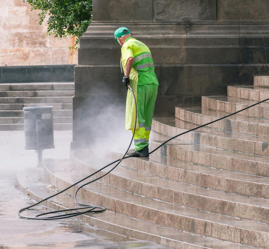 Photo by Antonio Lorenzana Bermejo A street worker pressure washes stone stairs in a public park, ensuring cleanliness and safety.